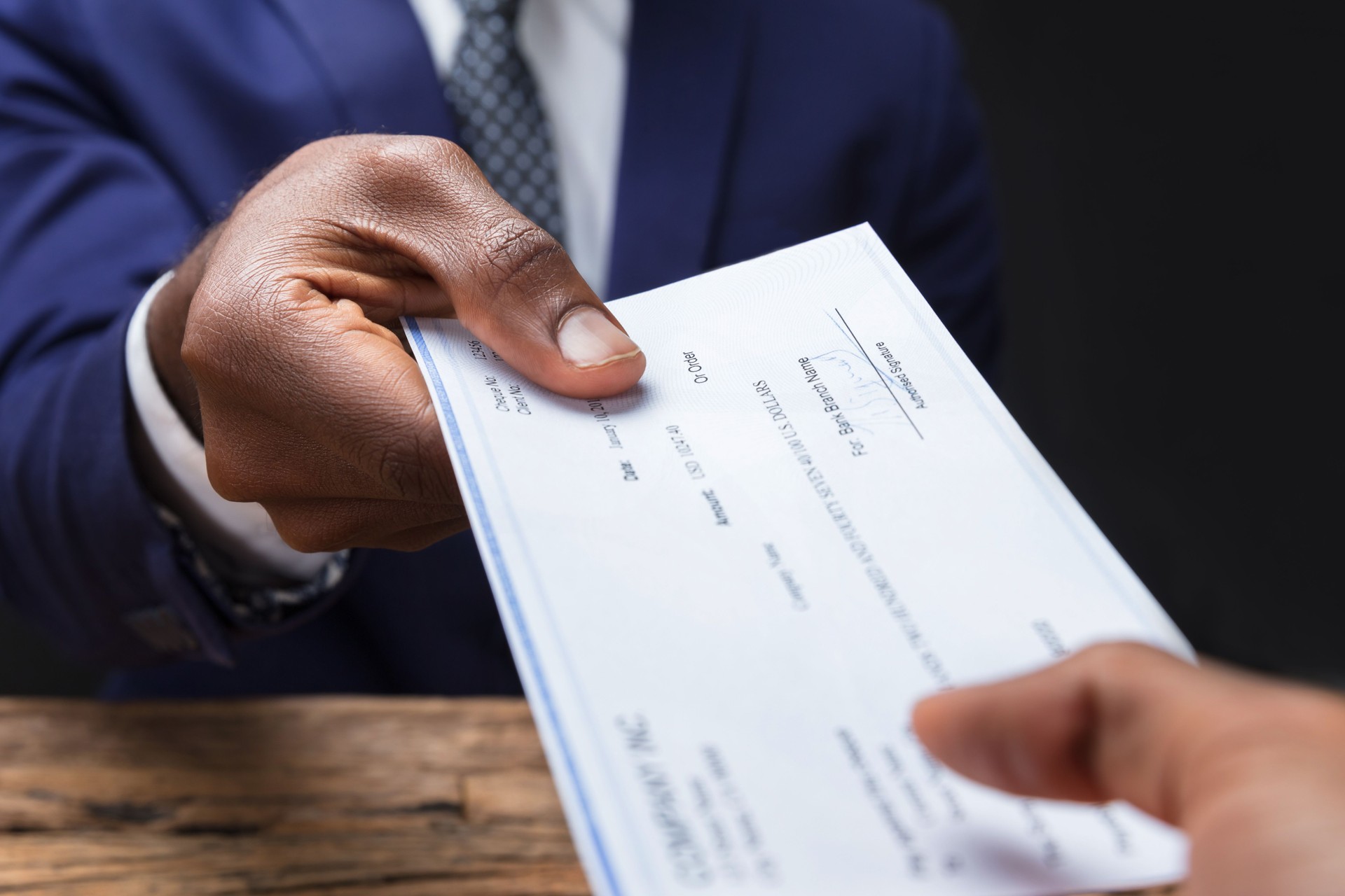 Businessman Giving Cheque To His Colleague